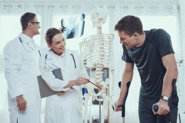 Doktor yaralı bir sporcunun röntgenine bakıyor.