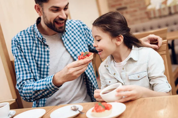 Père avec fille manger des gâteaux à la cafétéria. — Photo