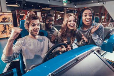 Arkadaşlar yarış oynayan bir arkadaşa destek olur. 