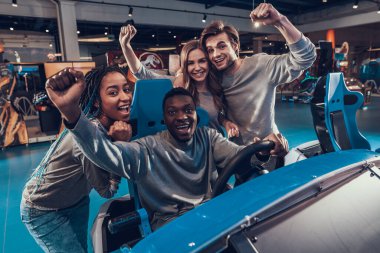 Genç arkadaşlar bir arkadaşın yanında durur ve sevinirler..