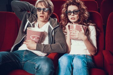 Patlamış mısırlı genç çift sinemada korku filmi izliyor..