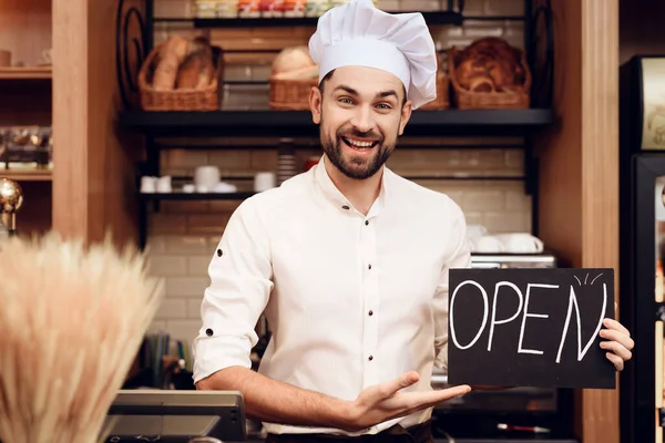 Jonge gelukkige man met open haard in de bakkerij. — Stockfoto