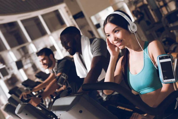 Chica está entrenando en auriculares con un teléfono. — Foto de Stock