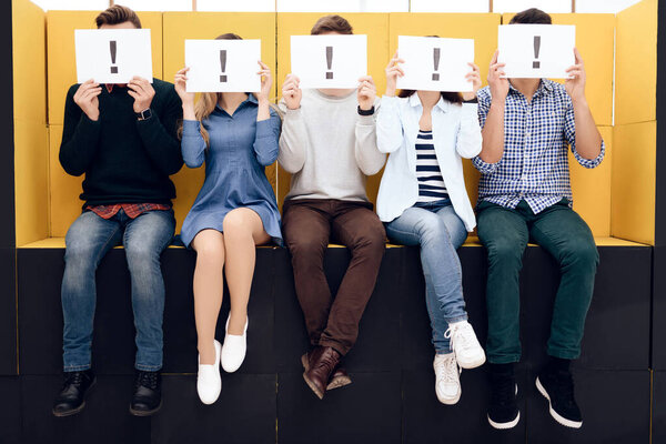 Group of people holding exclamation mark sign.