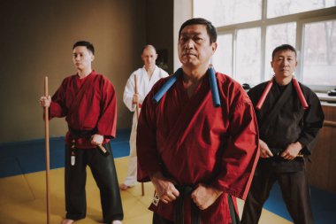 Boynunda mınçıka olan bir adam spor salonunda duruyor..