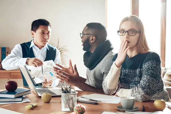 Los hombres se sientan a la mesa en la oficina y discuten. — Foto de Stock