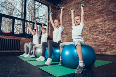 Aile gülümsüyor ve spor salonunda egzersiz yapıyor..