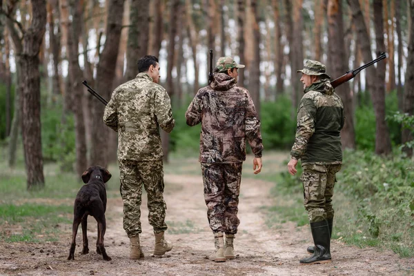 Hombres en Cazadores de Camuflaje Caminan Away by Path. — Foto de Stock