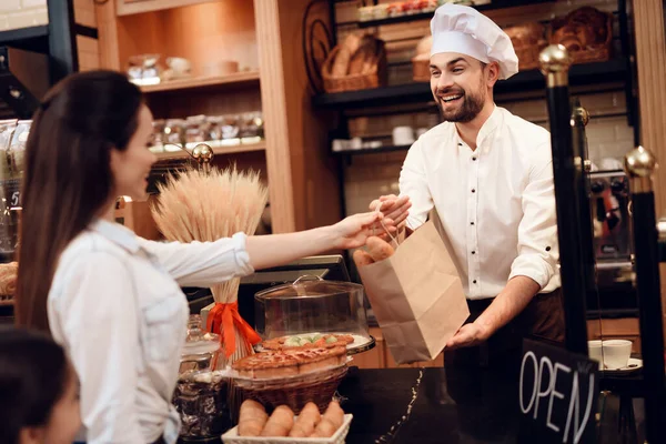 Jonge glimlachende vrouw koopt brood in de moderne bakkerij. — Stockfoto