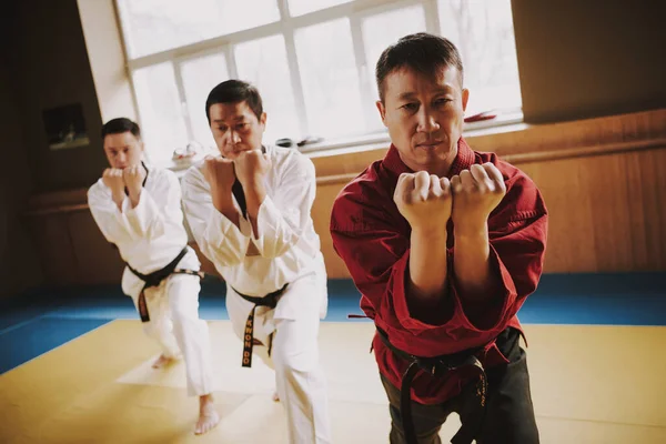 Two men in kimono practice techniques with teacher — Stock Photo, Image