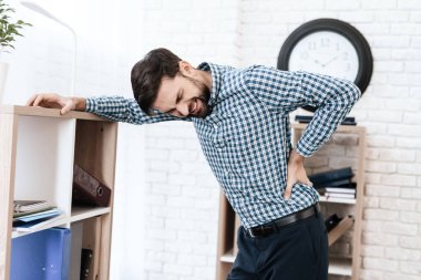 Sırtını tutan ve acı çeken adam.