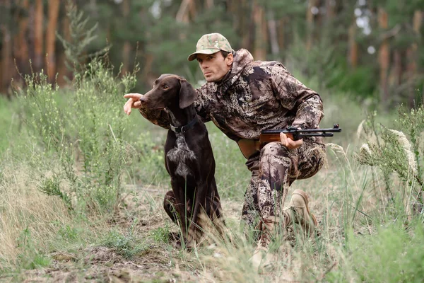 Hunter le da el mando a inteligente perro persiguiendo animales. — Foto de Stock