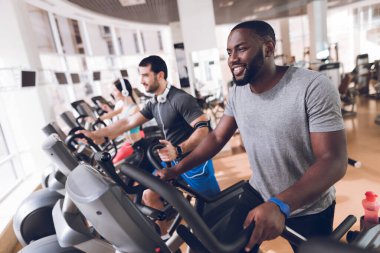 Spor salonundaki insanlar koşup vücudu sallıyorlar..