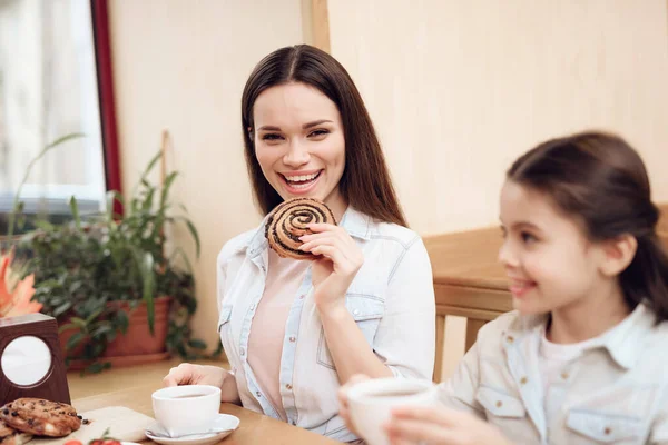 Jeune famille heureuse manger des gâteaux à la cafétéria. — Photo