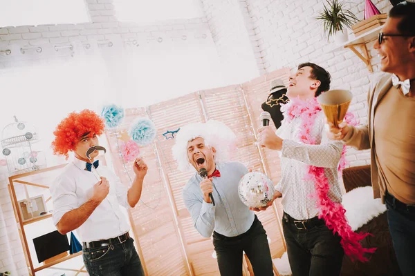 Un hombre con peluca sostiene una bola disco en una fiesta gay. —  Fotos de Stock