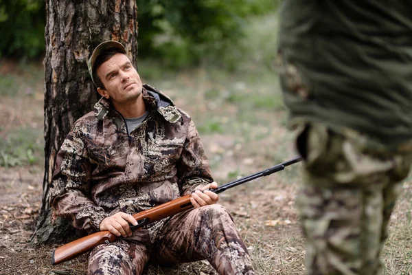 Cazador con rifle tiene resto hombres cazando en el bosque. — Foto de Stock