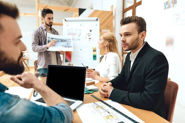 Un hombre con traje se sienta en una mesa con sus colegas.. — Foto de Stock