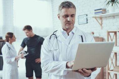 Doktor görevdeyken dizüstü bilgisayara bakıyor..