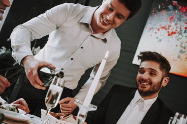 Bir adam bardağa şampanya dolduruyor.. 