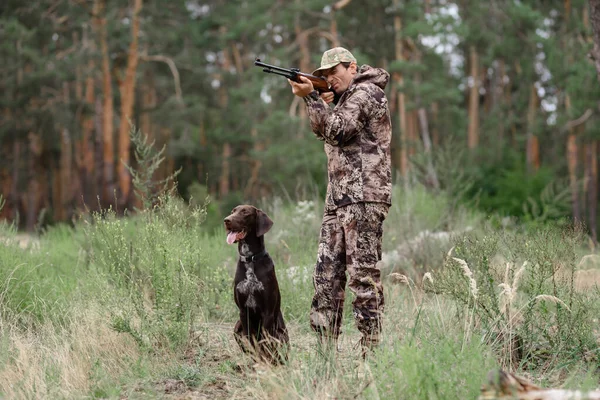 Hombre apuntando con caza de rifles en el bosque de verano. — Foto de Stock