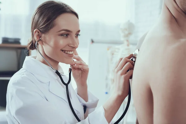 Mulher médico está sorrindo e ouvindo paciente. — Fotografia de Stock