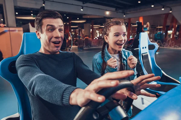 Cheerful dad and daughter are playing games.