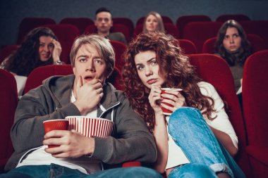 Kadın ve erkek korku filmi izlerken korkuyorlar.
