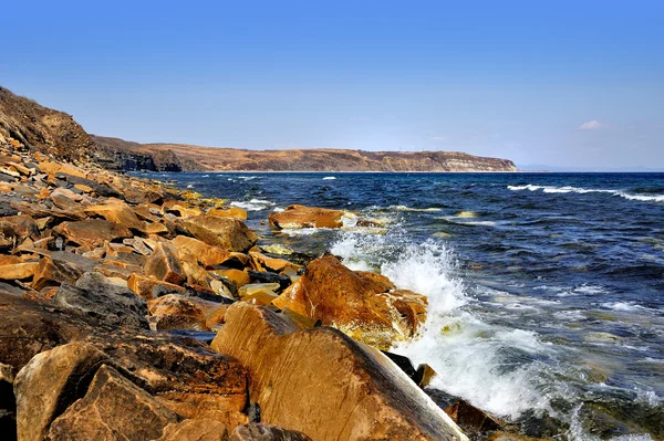 Orange rocks on sunny shore in spring — Stock Photo, Image