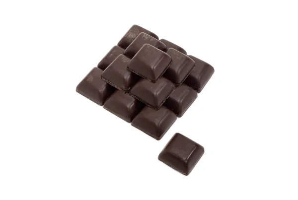 Pieces of dark chocolate on a light background — Stock Photo, Image