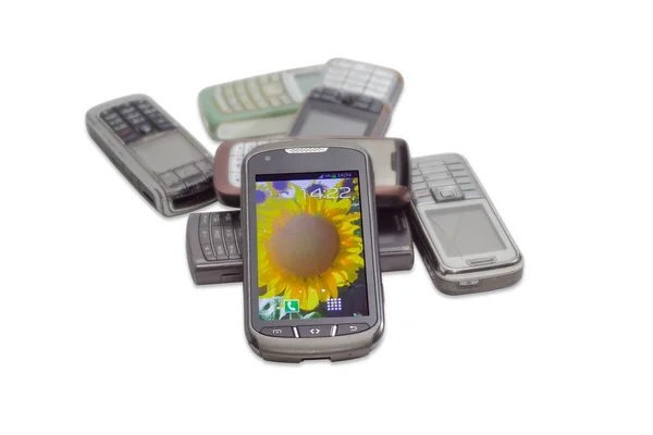 Modern smartphone on the background of old mobile phones — Stock Photo, Image