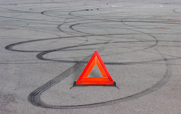 Výstražný trojúhelník a pneumatiky skladeb na asfaltu — Stock fotografie