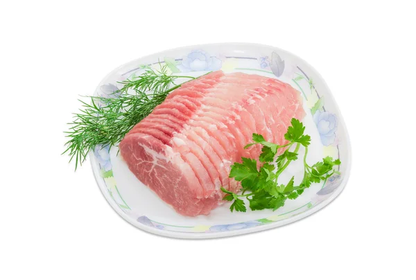 Sliced uncooked pork tenderloin and sprigs of parsley and dill — Stock Photo, Image