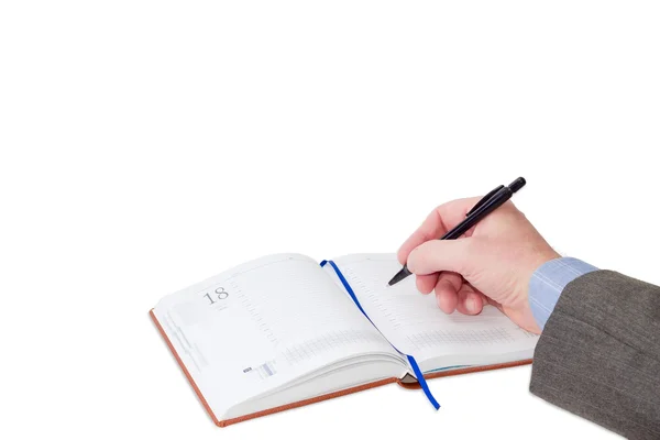 Männliche Hand mit Stift über Geschäftstagebuch auf hellem Hintergrund — Stockfoto