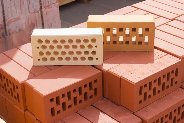 Dos ladrillos perforados de diferentes colores y formas de agujeros —  Fotos de Stock