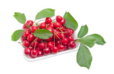 Tatlı kiraz ile plastik tepsi ve dalları ile bırakır