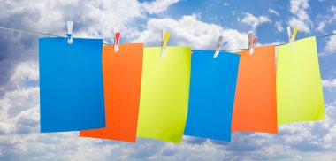 Renkli kağıda tutturmak bir clothespins gökyüzüne karşı