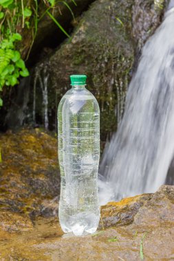 İçme suyu dağ dere arka plan üzerinde şişe
