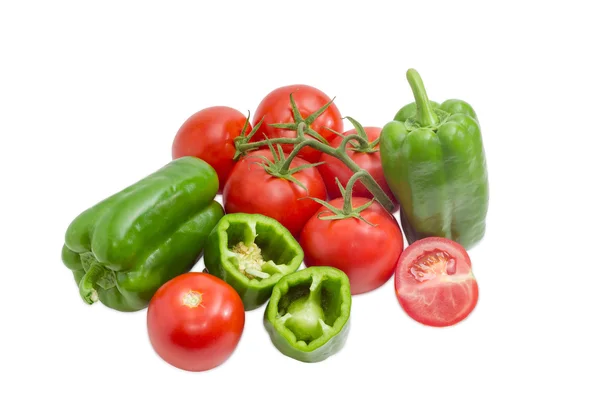 Mehrere grüne Paprika und Tomaten auf hellem Hintergrund — Stockfoto