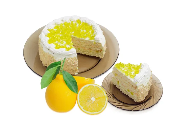 Layered cake with lemon jelly on glass dishes and lemons — Stock Photo, Image