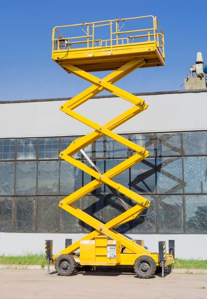 Elevador autopropulsado de tijera en el fondo de la burbuja industrial — Foto de Stock