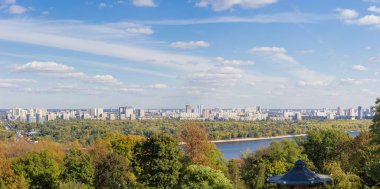 Gökdelenli ve çok katlı binalar, nehir ve sonbahar parklarının ağaçlarıyla modern şehrin bir parçası, panoramik manzara