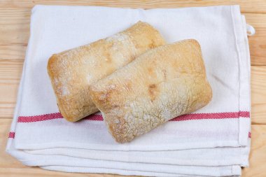İki koca ciabatta kumaş peçetenin üzerinde yatıyor.