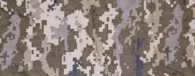 Fragment of slightly crumpled fabric with pixellated digital camouflage pattern dull olive-green and gray color. Panoramic view, background, texture clipart