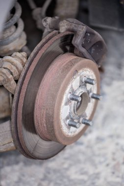 Kullanılmış bir arabanın arka disk fren ve tekerlek merkezini, seçici odak noktasında tekerleği kaldırılmış görünümü