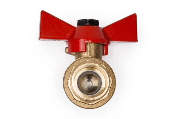 Closed ball valve with brass body and red butterfly handle on a white background, view of the valve insides from threaded connection side close-up in selective focus
