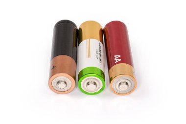 Beyaz yüzey üzerinde farklı alkali piller AA boyutu, pozitif uçbirimlerden görünüm