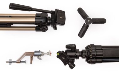 Çeşitli fotografik tripodların parçaları, masa üstü mini tripodları ve beyaz arkaplanda farklı başlıklı kamera bağlanma parantezi, üst görünüm