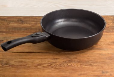 Modern boş döküm tava, seramik yapışmaz kaplama ile alüminyum alaşım ve eski bir rustik masa üzerinde çıkarılabilir sapı