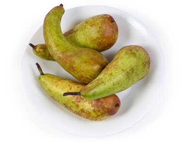 Konferans armutlarının olgun yeşilimsi kahverengi armutları beyaz arka planda beyaz bir çanakta, üst tarafta.