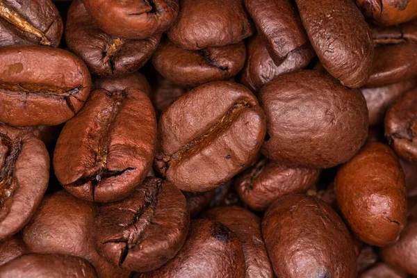Roasted coffee beans in a pile, top view. Close-up in selective focus, background, texture